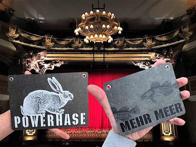 Kladdenjan Bayernbub und Mehr Meer Postkarten und Grußkarten in der Hand im Theater